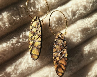 Woodburned and painted oval wood earrings with burned line work and gold shading
