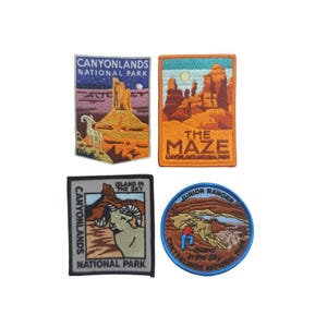 Könnte beinhalten: Vier gestickte Aufnäher mit Motiven aus dem Canyonlands National Park. Die Aufnäher sind rechteckig und zeigen verschiedene Szenen aus dem Park, darunter eine Ansicht der "Insel im Himmel" und des "Labyrinths". Ein Aufnäher ist rund und zeigt einen Junior Ranger mit dem Text "Insel im Himmel" und "Canyonlands National Park".