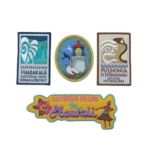 May include: Five embroidered patches featuring Hawaiian landmarks and text. The patches are yellow, blue, green, brown, and white. The patches feature the text "HALEAKALA NATIONAL PARK KIPAHULU DISTRICT", "KILAUEN POINT NATIONAL WILDLIFE REFUGE KALA", "PUUHONUA O HONAUNAU NATIONAL HISTORICAL PARK", and "SUMMER PALMS in Hawaii".