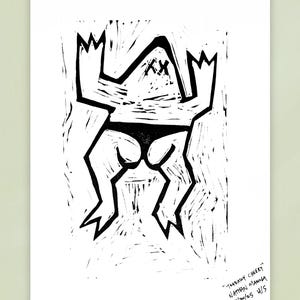 Op de afbeelding: Zwart-wit linoleumsnede van een gestileerde figuur met een driehoekig hoofd, doorgestreepte ogen en een bikinibroekje. De figuur heeft grillige armen en benen. De prent is getiteld "Totally Cheeky" door Nathan Mancha, gedateerd 30/11/25 en genummerd 4/5.