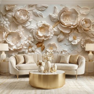 May include: A luxurious living room featuring a cream-colored sofa with gold accents, a round gold coffee table, and a floral wall mural. The room is decorated with matching lamps and a rug, creating a cohesive and elegant space.
