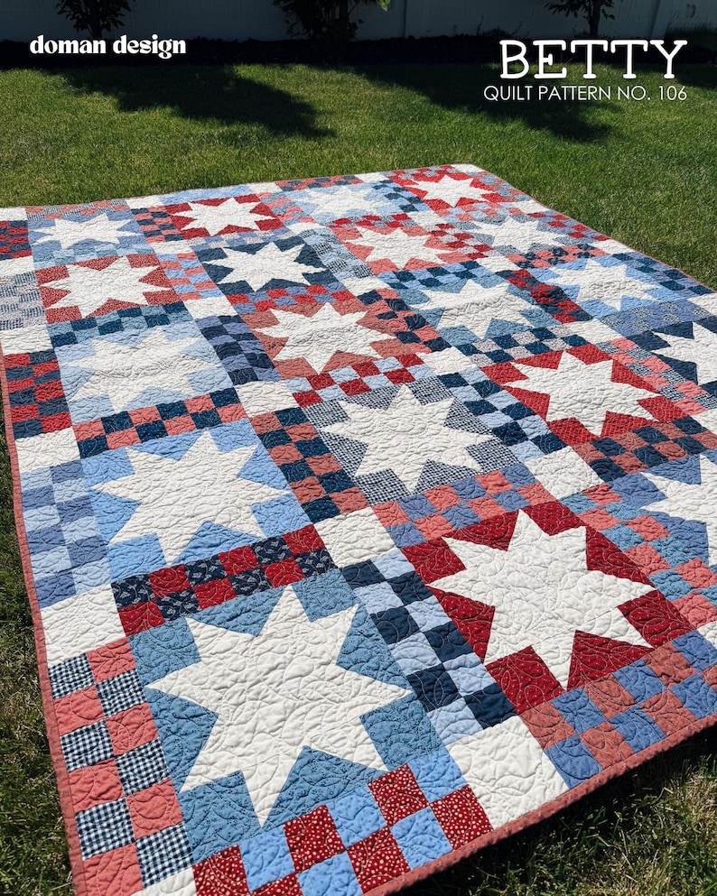 May include: A quilt featuring a repeating pattern of white stars set against a background of red, white, and blue checkered squares. The text 'doman design' and 'BETTY QUILT PATTERN NO. 106' is printed in the upper corners of the image.