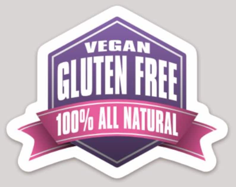 May include: A white sticker with a purple and pink design. The sticker has the words "VEGAN" and "GLUTEN FREE" in white, with "100% ALL NATURAL" on a pink ribbon.