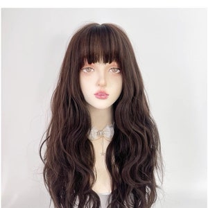 May include: A long, brown wig with loose waves and a full fringe. The wig is styled on a mannequin head.