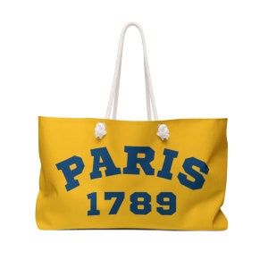 May include: A yellow canvas tote bag with white rope handles. The bag has the text "PARIS 1789" printed in blue.