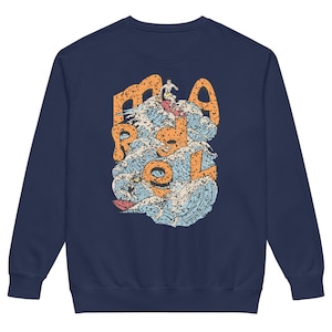 Puede incluir: Sudadera azul marino con un diseño de surf. El diseño incluye las palabras "Ride Roll" en naranja, con surfistas y olas en azul, blanco y naranja. Una prenda casual y cómoda.