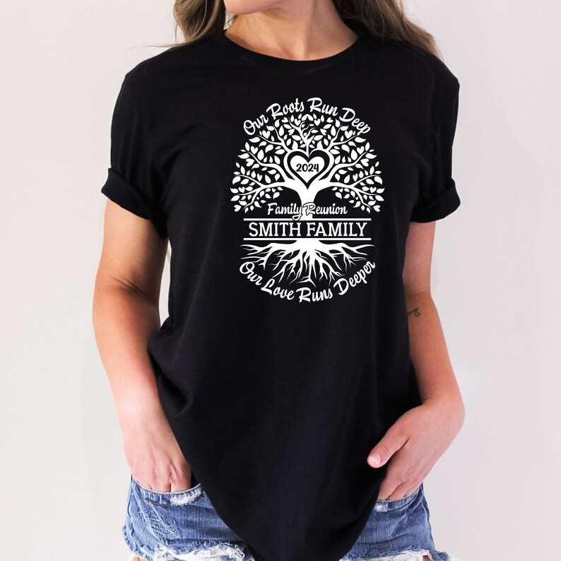 May include: Black t-shirt with a white tree design. The tree has a heart with the year 2024 inside. The text "Our Roots Run Deep" is above the tree, "Family Reunion" is below the tree, and "SMITH FAMILY" is in a banner below the text. The text "Our Love Runs Deeper" is below the roots of the tree.