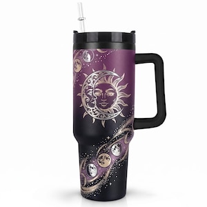 May include: A tall, insulated tumbler with a black handle, a black lid, and a clear straw. The body features a gradient from deep purple to black, decorated with a metallic gold sun and crescent moon design, along with various moon phases.