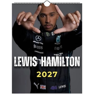 Może przedstawiać: Kalendarz ścienny na 2027 rok z portretem Lewisa Hamiltona w czarnym kombinezonie wyścigowym Mercedes z różnymi logotypami sponsorów, w tym Petronas, UBS i IWC. Napis LEWIS HAMILTON oraz 2027 wydrukowano w kolorze białym i żółtym.