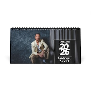 May include: A 2026 calendar featuring a photograph of Andrew Scott. The calendar has a black spiral binding and a black and white design. The cover displays the text "CALENDAR 2026" and "Andrew Scott."