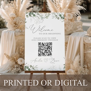 May include: A white rectangular wedding welcome sign featuring green eucalyptus leaf illustrations at the top and bottom. The text reads Welcome TO OUR BEGINNING PLEASE SCAN TO VIEW OUR CEREMONY PROGRAM, a central QR code, and the names Amelia & Bruce.