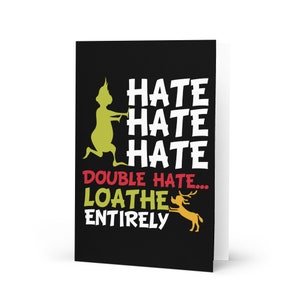 May include: A folded greeting card with a black background and white text that reads "HATE HATE HATE DOUBLE HATE... LOATHE ENTIRELY". The card features a green cartoon character and a yellow reindeer.