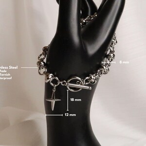 Puede incluir: Un brazalete de acero inoxidable plateado con cierre de palanca y un dije de estrella. El brazalete tiene 8 mm de ancho y el dije tiene 12 mm de ancho y 18 mm de largo. El brazalete es impermeable y resistente al deslustre.