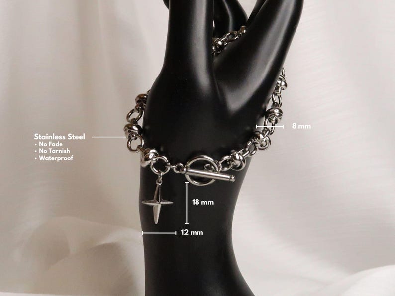 Puede incluir: Un brazalete de acero inoxidable plateado con cierre de palanca y un dije de estrella. El brazalete tiene 8 mm de ancho y el dije tiene 12 mm de ancho y 18 mm de largo. El brazalete es impermeable y resistente al deslustre.