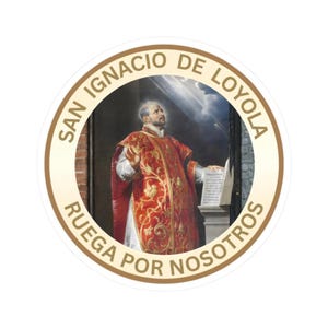 May include: A circular sticker featuring a painting of Saint Ignatius of Loyola in a red and gold vestment, looking upward. The border is cream-coloured with the text SAN IGNACIO DE LOYOLA RUEGA POR NOSOTROS printed in gold capital letters.