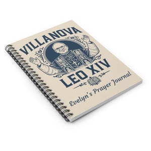 Puede incluir: Un diario encuadernado en espiral con una cubierta color crema. La cubierta presenta el texto azul marino "VILLANOVA LEO XIV Evelyn's Prayer Journal" y una ilustración de un hombre con vestimenta religiosa.