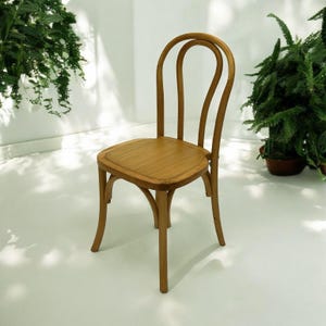 May include: A wooden chair with a rounded back and a simple design. The chair is made of light brown wood and has a natural finish.