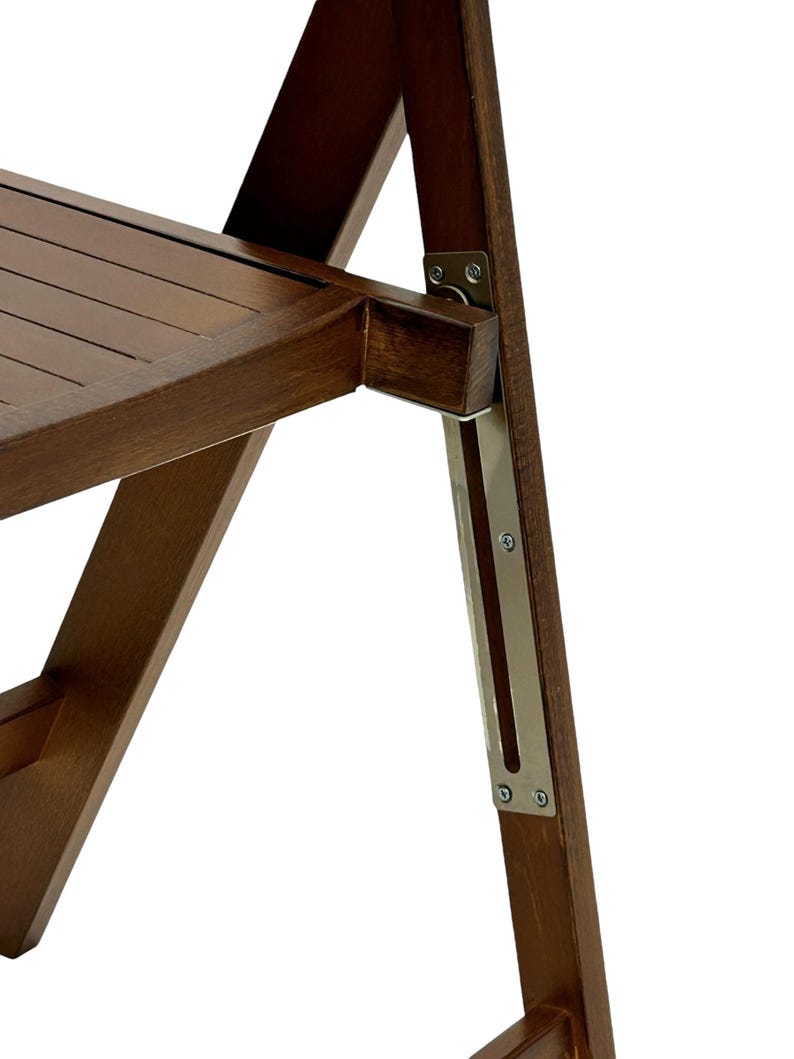 May include: Close-up of a wooden folding chair with a metal hinge and support. The chair is made of dark brown wood and has a slatted seat.