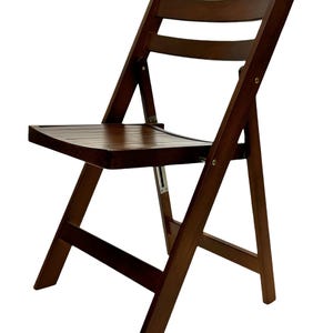 May include: A dark brown wooden folding chair with a slatted back and seat. The chair is made of solid wood and has a simple, classic design.