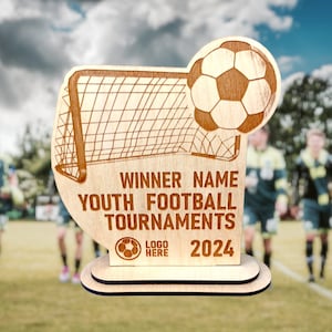 May include: Wooden soccer trophy with a soccer ball and goal post design. The trophy reads "WINNER NAME YOUTH FOOTBALL TOURNAMENTS 2024" and includes a space for a logo. The trophy is on a two-tiered base.