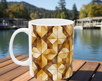 Taza blanca con un patrón de vitrales en tonos marrón y dorado. El patrón presenta formas geométricas intrincadas que combinan tonos cálidos.