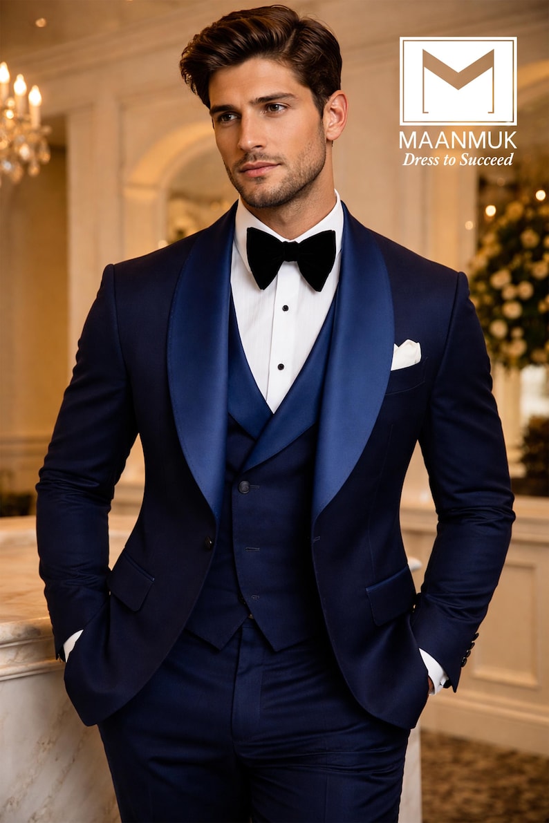 Puede incluir: Un traje de tres piezas azul marino con solapa de sat&eacute;n, camisa blanca y pajarita negra. El traje incluye chaleco y pa&ntilde;uelo de bolsillo. La imagen incluye el texto "MAANMUK Dress to Succeed".