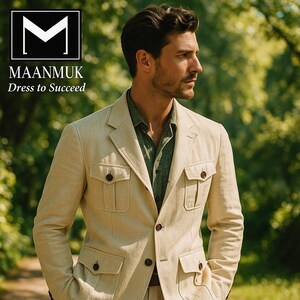 May include: Beige safari jacket with four front pockets and dark brown buttons. The jacket is worn over a green shirt. The text "MAANMUK Dress to Succeed" is in the upper left corner. The background is a blurred outdoor scene.