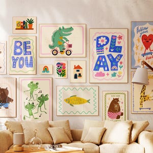 Peut inclure: Une collection d'impressions d'art encadrées avec des illustrations fantaisistes. Les impressions présentent des animaux comme un crocodile à vélo, des grenouilles dansant et un ours. D'autres impressions affichent les mots "BE YOU" et "PLAY". La palette de couleurs comprend des pastels et des couleurs vives.