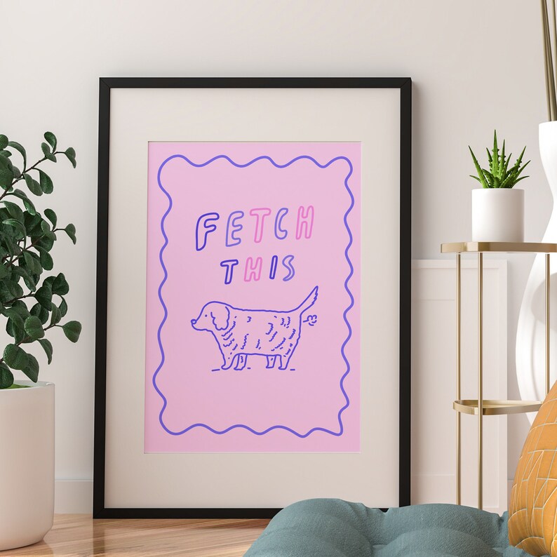 May include: A pink and purple print with a cartoon dog and the text "FETCH THIS" in a black frame.