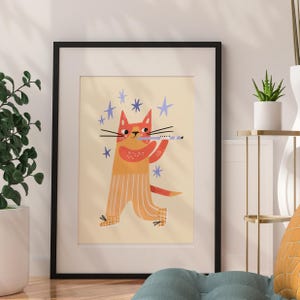 May include: Framed art print featuring a whimsical illustration of an orange cat playing a flute. The cat is wearing striped pants and surrounded by blue star shapes. The artwork has a cream-colored background and is framed in black.