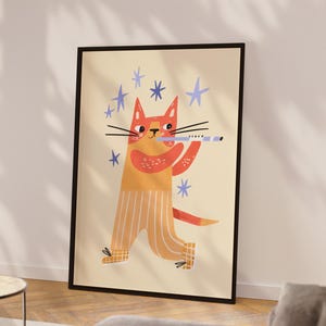 May include: A framed art print featuring a whimsical illustration of a cat playing a flute. The cat is orange and yellow, wearing striped pants, and surrounded by blue stars. The artwork has a playful, cartoonish style.