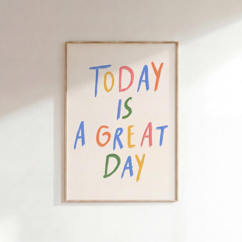 May include: A framed art print with the words "TODAY IS A GREAT DAY" in colorful, handwritten-style lettering. The text is in blue, pink, green, orange, yellow, and green. The frame is a light brown color.