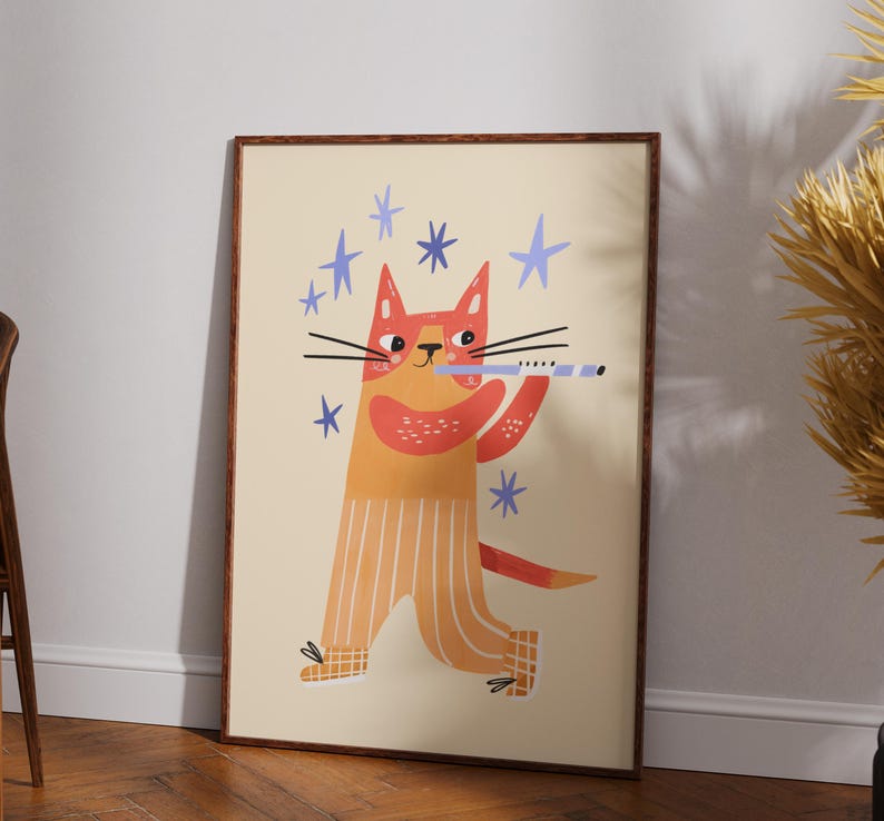 May include: A framed art print featuring a whimsical illustration of a cat playing a flute. The cat is depicted in shades of orange and yellow with blue star accents. The artwork has a playful and cheerful aesthetic.
