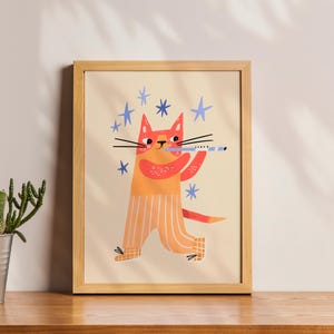May include: A framed art print featuring a whimsical illustration of an orange cat playing a blue flute. The cat wears orange and white striped pants and is surrounded by blue star shapes. The artwork is set against a cream background and framed in natural wood.