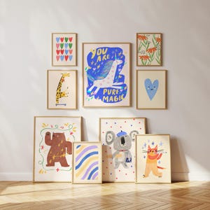 K&ouml;nnte beinhalten: Eine Sammlung gerahmter Kunstdrucke mit skurrilen Tierillustrationen und abstrakten Designs. Die Drucke zeigen eine Giraffe auf einem Skateboard, einen tanzenden B&auml;ren, einen Koala mit Hut und eine Katze, die Fl&ouml;te spielt. Weitere Drucke zeigen Herzen, Blumen und den Text "YOU ARE PURE MAGIC."