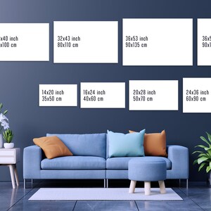 May include: A wall gallery display with six white frames of various sizes, showcasing different canvas print sizes in inches and centimeters. The frames are hung on a dark blue wall, with a blue sofa, a small table, and plants in the foreground.