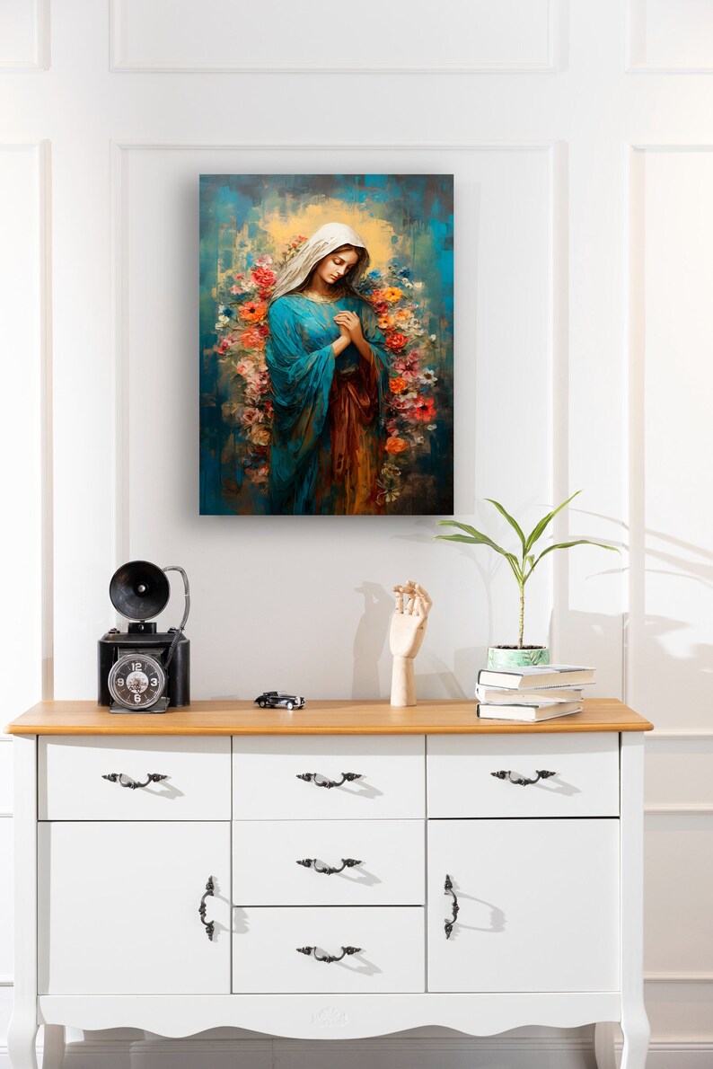 May include: A painting of the Virgin Mary in a blue robe with a crown of flowers around her head. The background is a blue and green abstract design.