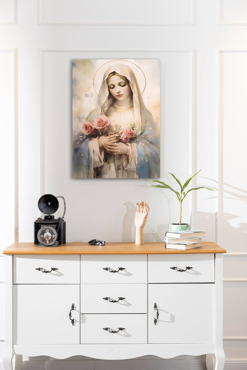 Pode incluir: Uma pintura da Virgem Maria segurando um buqu&ecirc; de rosas cor-de-rosa. Ela est&aacute; vestida com uma t&uacute;nica azul e branca e tem uma aur&eacute;ola acima da cabe&ccedil;a.