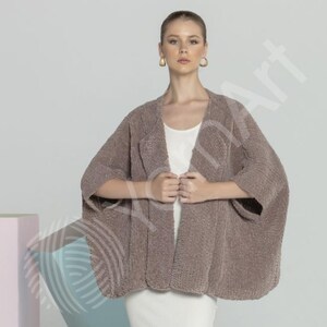 May include: A brown, open-front cardigan with wide sleeves. The soft, textured knitwear is worn over a white top and a white skirt. The cardigan is a neutral colour, suitable for layering.