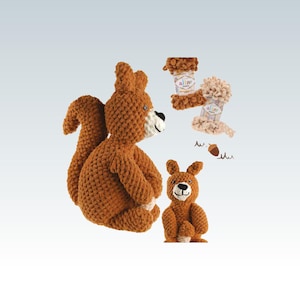 Pode incluir: Uma cole&ccedil;&atilde;o de brinquedos de esquilo de croch&ecirc; feitos &agrave; m&atilde;o em tons de castanho. A imagem inclui um esquilo grande, um esquilo menor e dois potes de fio. Os brinquedos t&ecirc;m tra&ccedil;os faciais em preto e branco sobre um fundo azul claro.