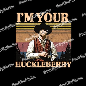 May include: A graphic design on a black background featuring a man in a cowboy hat and vest. The text "I'M YOUR HUCKLEBERRY" is above and below the image of the man. The design has a vintage, retro style.