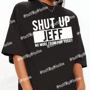 May include: Black t-shirt with the text "SHUT UP JEFF" in white block letters. Below the name is the phrase "NO MORE FROM YOU TODAY". The shirt has short sleeves and a crew neck.