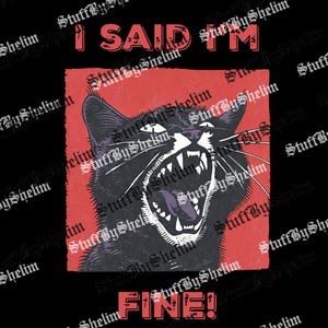 May include: Black cat graphic with the text "I SAID I'M FINE!" in red. The cat is depicted with an open mouth, bared teeth, and a purple tongue, set against a red background. The design has a distressed, vintage aesthetic.