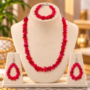 May include: A jewelry set consisting of a necklace, a bracelet, and a pair of drop earrings, all crafted from irregular, vibrant hot pink chip beads. The necklace and bracelet feature silver-toned metal clasps, while the earrings have hooks.