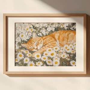 May include: A framed print of a ginger cat sleeping in a field of white daisies.