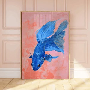 Peut inclure: Une peinture d'un poisson combattant bleu aux nageoires flottantes sur une toile avec un fond rose. La peinture est encadrée dans un cadre en bois clair.