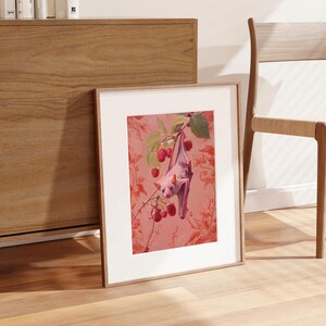May include: A framed print of a pink bat hanging upside down from a branch of a pink flowering tree. The background is a pink floral pattern.