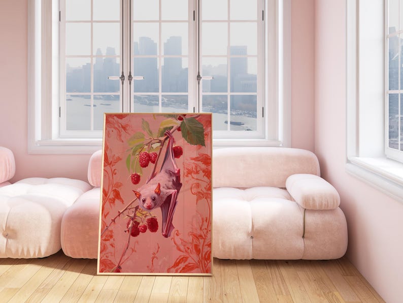 May include: A framed painting of a pink bat hanging upside down from a branch of a raspberry bush. The bat is surrounded by red raspberries and green leaves. The background is a pink and red floral pattern.