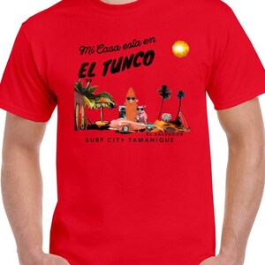 May include: Red t-shirt with a graphic design of a beach scene with a car, palm trees, and the text "Mi Casa esta en El Tunco Surf City Tamanique El Salvador".