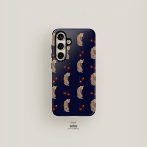 May include: A navy blue phone case with a repeating pattern of small leopards and red cherries. The case has a raised camera bump with three lenses.